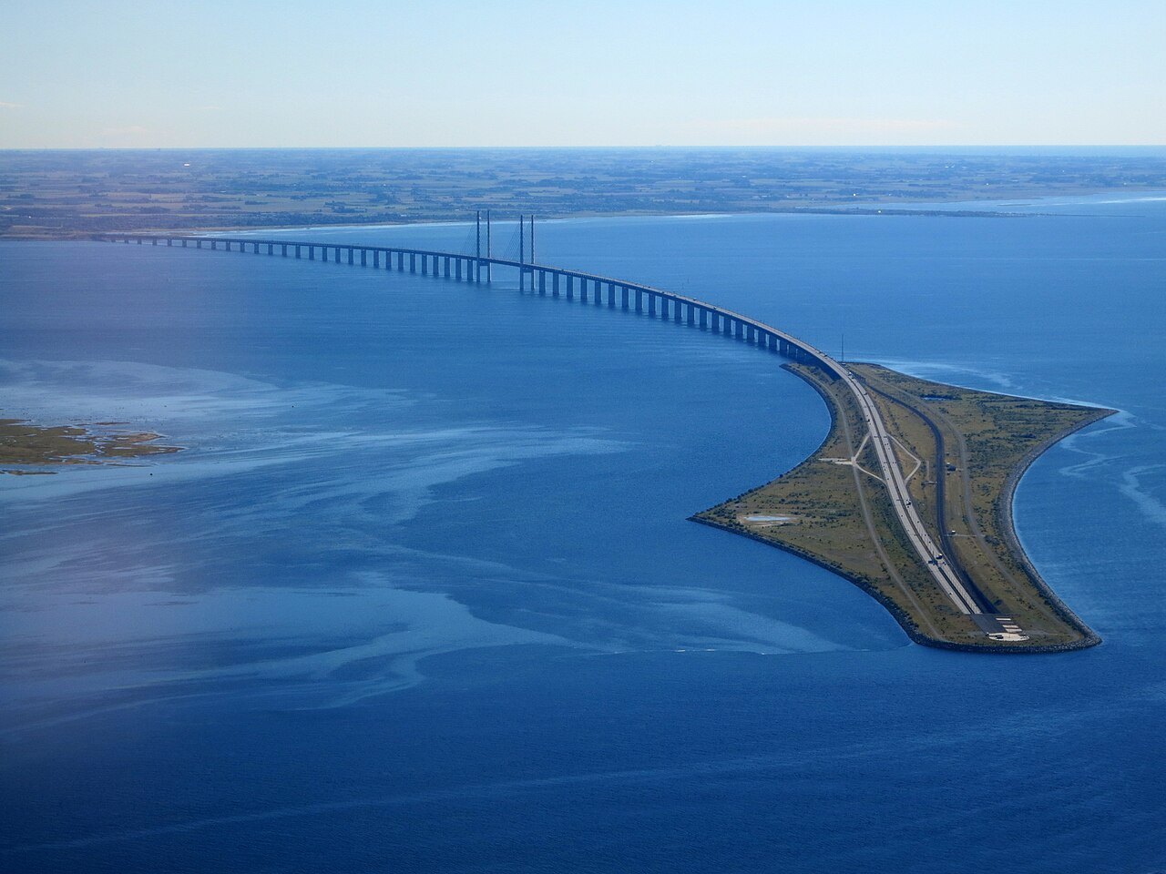 Luftfoto af Øresundsforbindelsen, hvor vejen løber over havet og Peberholm.